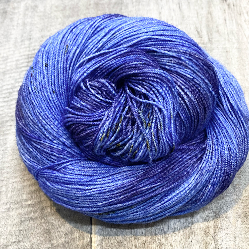 A swirl of hand dyed wool in colour, 'Moody', a range of blues with sprinkles in browns.